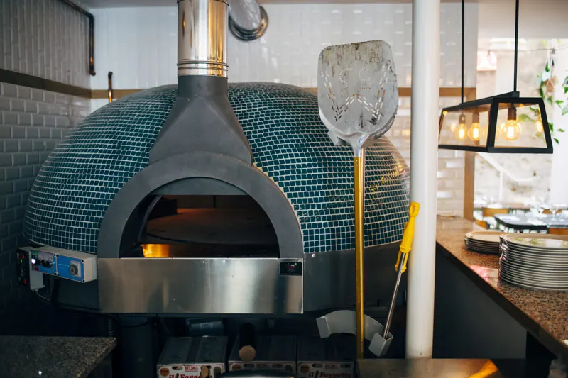 Four à pizza traditionnel en faïence verte chez Pizzou