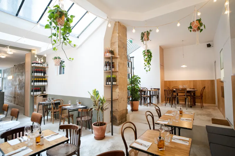 La salle de la pizzeria Pizzou Aligre sous sa verrière, plantes suspendues, rue de Cotte à Paris 12e