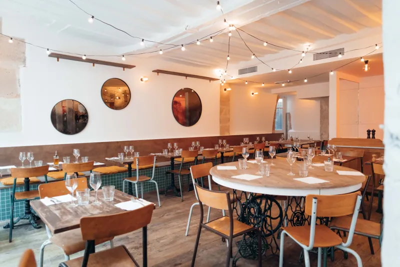 La salle de la pizzeria Pizzou Marais, miroirs ronds et guirlandes, rue du Bourg Tibourg à Paris 4e